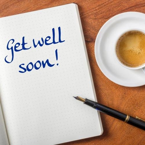 Get well soon written on a paper with a cup of tea